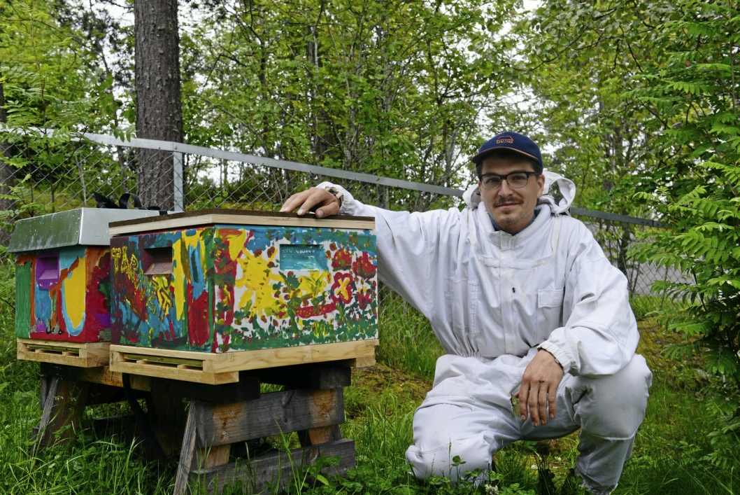 STÅR BARNA BI: Birøkter Mikkel Kostveit Dagestad, hjelper barna i Hareveien å ta vare på biene, som bor i flotte kuber malt av barna selv.