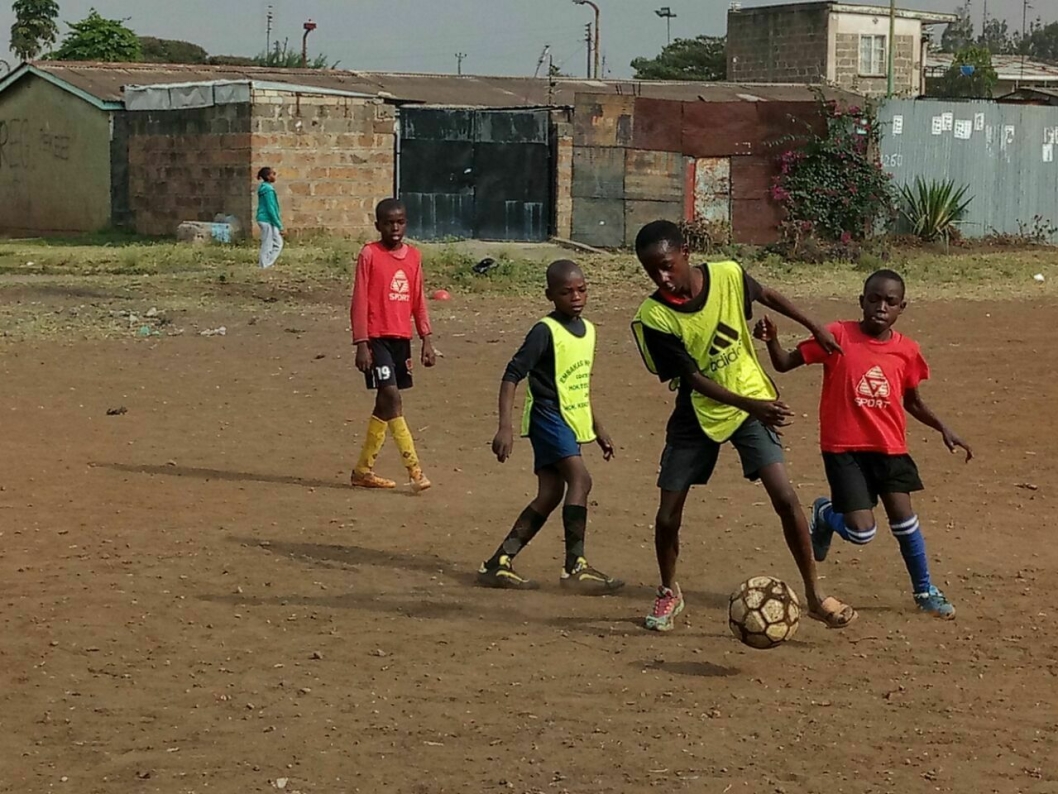 VANSKELIGE FORHOLD: Barna spiller fotball på grusunderlag. Ikke akkurat "gnistrende forhold."