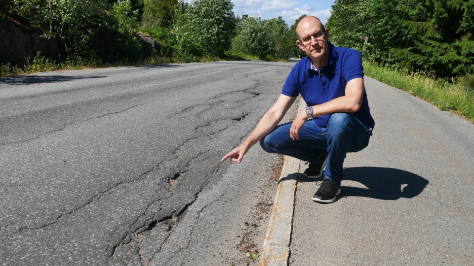 PROVOSERT: – Hvis kommunen mener at denne strekningen ikke er dårlig nok til asfaltering kan man begynne å lure, sier Rune Torgersen mens han peker på de store sprekkene og hullene i den slitte veien.