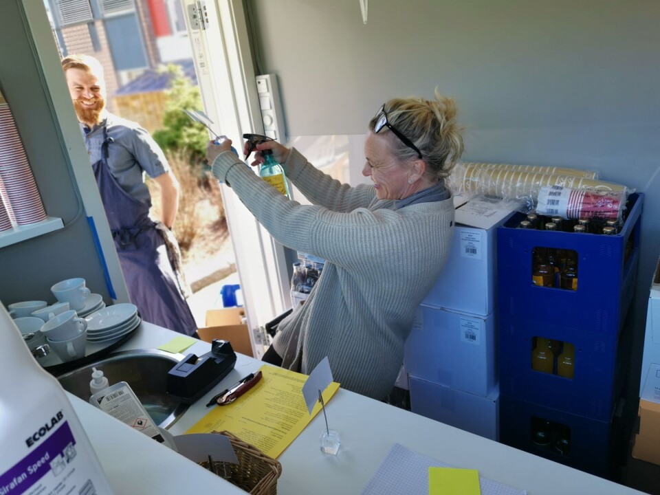 DESINFISERING: Medeier Helene Jahren desinfiserte bordkort mens kjøkkensjef Torstein Sørum Sogn fulgte med. DESINFISERING: Medeier Helene Jahren desinfiserte bordkort mens kjøkkensjef Torstein Sørum Sogn fulgte med.