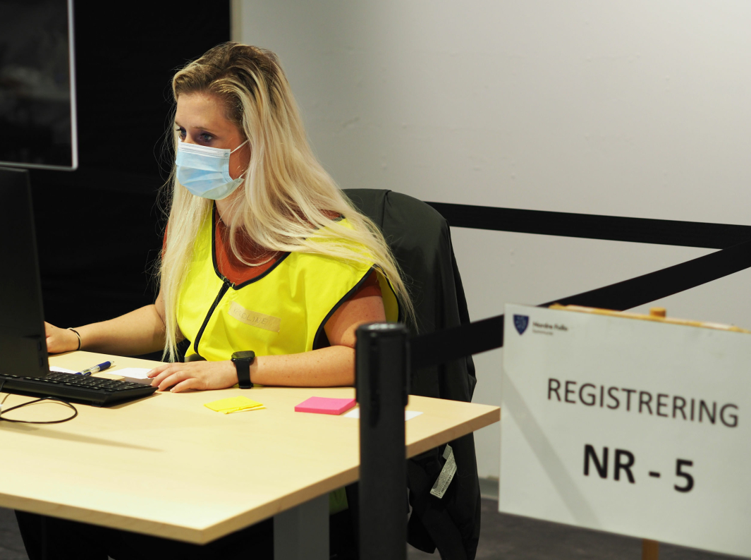 53 PROSENT FIKK FØRSTE DOSE: På bildet kan du se Karoline Ringstad, som hjelper til med registrering til vaksinering på Ski Storsenter. Foto: Nordre Follo kommune