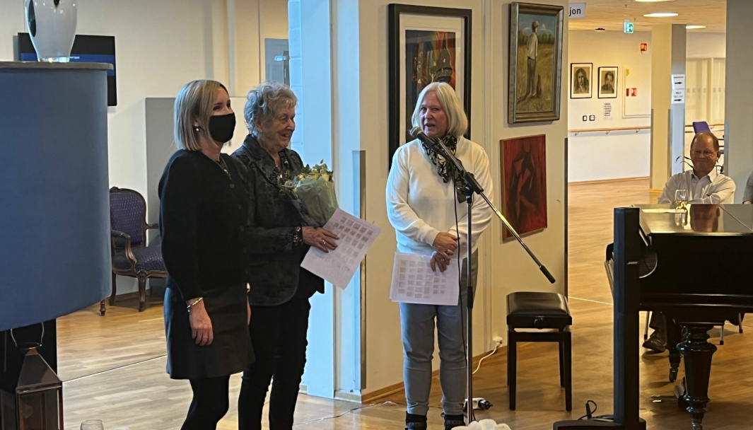 UTSTILLING: Kunstneren Laila S. Thoresen stilte ut egne bilder på Høyås. Her sammen med pårørende under presentasjon og blomsteroverrekkelse. I bakgrunnen pianist Sverre Dyrhaug.