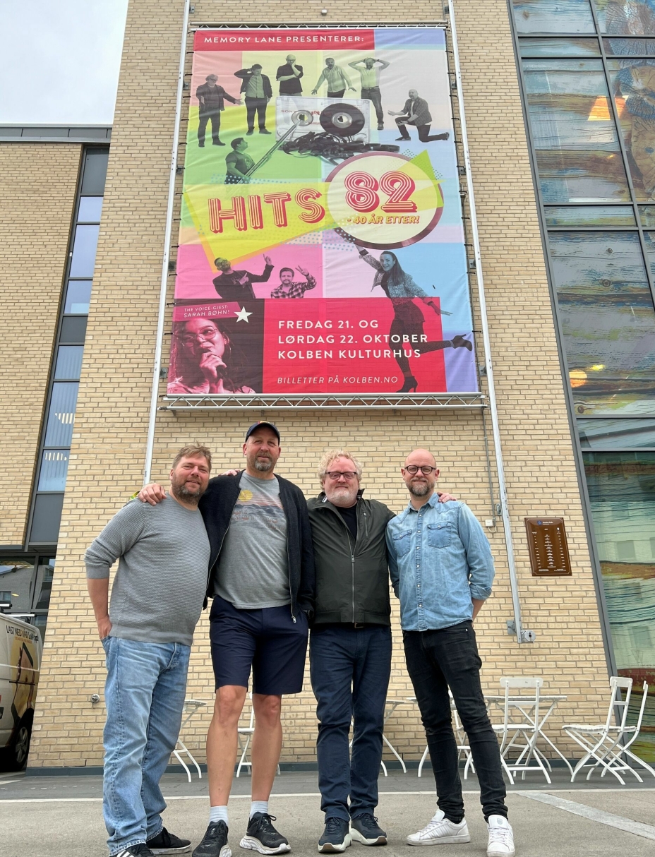 HITS 82: Fire av bandmedlemmene foran plakaten på Kolben.
