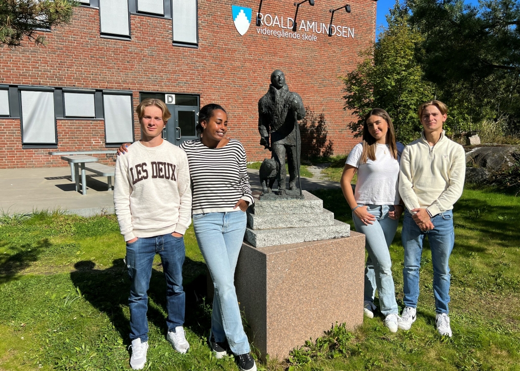 ARRANGØRER: Idrettslinje-elevene Luca Roverudseter, Sara Libanos, Tyra Langmyr Iochev og Sigve Lind, flankerer polarhelten Roald Amundsen.