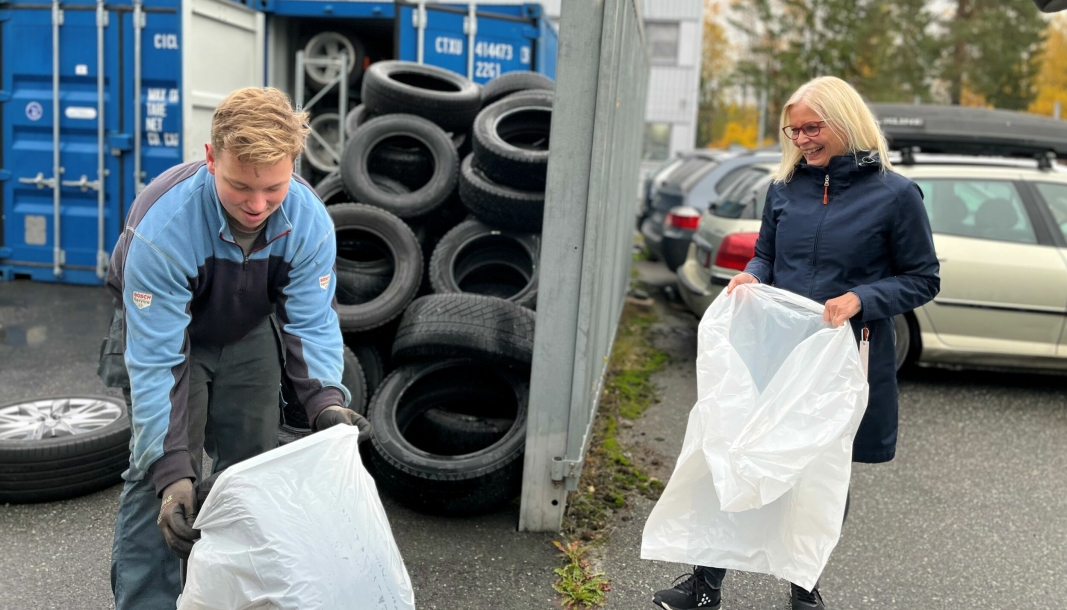 EKSTRASERVICE: Theodor Syverstad Kristiansen hjelper kunde Monica Nauen med å løfte dekkene opp i bilen. Det er en del av pakka med dekkhotell.